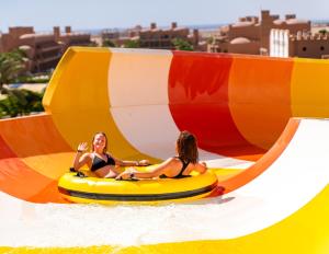 two women riding on an inflatable raft in a water park at Akassia Swiss Resort in Quseir