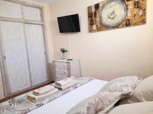 a bedroom with a bed and a tv and a window at Mareverde Amplio apartamento 1 dormitorio in Adeje +30 photos