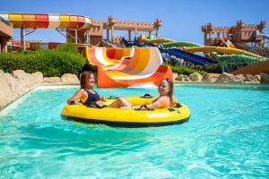 Deux femmes montent sur un tube intérieur dans un parc aquatique dans l'établissement Akassia Swiss Resort, à Al-Qusair