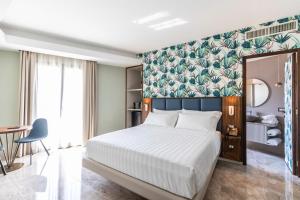 Solmaris Tropea Rooms & Suites في تروبيا: غرفة نوم بسرير كبير وبجدار اخضر
