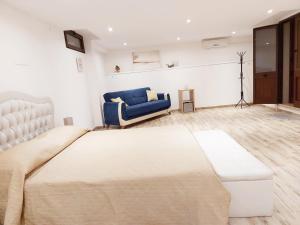 a bedroom with a large bed and a blue chair at B&B Acchiappasogni in Corigliano dʼOtranto