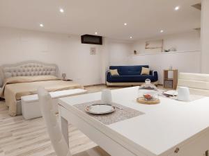 a white room with a bed and a dining table at B&B Acchiappasogni in Corigliano dʼOtranto