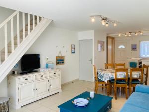 ein Wohnzimmer mit einem blauen Sofa und einem Tisch in der Unterkunft Maison de l'océan, convivialité et plage à 300m in Saint-Jean-de-Monts