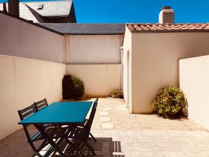 einen blauen Tisch und Stühle auf einer Terrasse in der Unterkunft Maison de l'océan, convivialité et plage à 300m in Saint-Jean-de-Monts