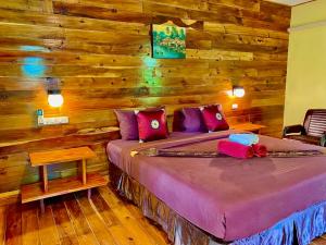 a bedroom with a bed with wooden walls at Coconut Lanta Resort @Klong Dow beach in Krabi town