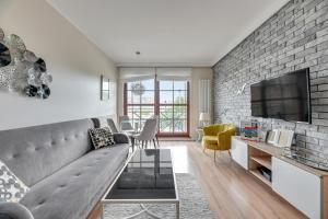 a living room with a couch and a tv at Dom & House - Apartments Nowa Motława in Gdańsk