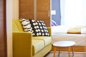 東京にあるSG Premium KASAIのソファ、ベッド、テーブルが備わる客室です。