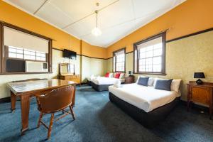 a hotel room with a bed and a desk at Strathfield Hotel in Sydney