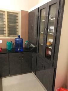uma casa de banho com armários de madeira escura e um espelho grande em GIRI Service Apartment em Tirupati
