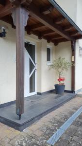 une terrasse couverte avec une porte en bois et un pot dans l'établissement Ferienhaus Am Reilsbach, à Cochem