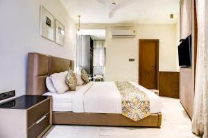a hotel room with a bed and a television at FabHotel Prime Oasis Blue in Bhopal