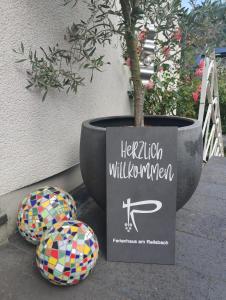 a potted tree in a pot next to two balls at Ferienhaus Am Reilsbach in Cochem