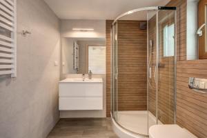 bagno con lavandino e doccia di Natural Resort a Gąski