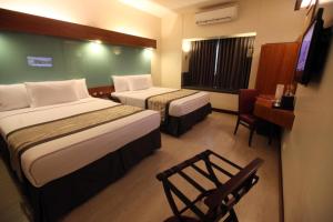 A bed or beds in a room at Microtel by Wyndham UP Technohub