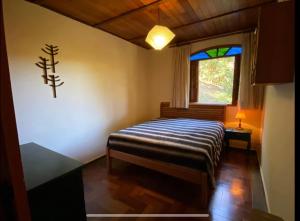 En eller flere senge i et værelse på Casa do Curupira - 3 dormitórios com cozinha e vista incrível perto de Campos do Jordão