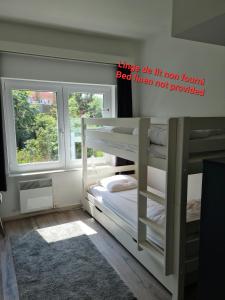 a bedroom with two bunk beds and a window at Appartement 2 chambres 200m plage Nieuwpoort Bad in Nieuwpoort