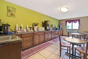 a kitchen with wooden cabinets and a table and chairs at Super 8 by Wyndham Mentor/Cleveland Area in Mentor