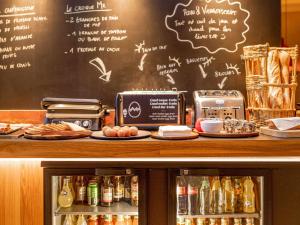 een aanrecht met een krijtbord met een menu en eten bij Ibis Styles St Etienne - Gare Chateaucreux in Saint-Étienne
