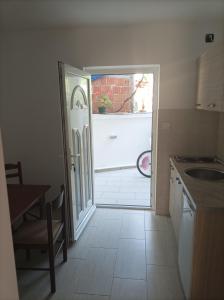 a kitchen with a door leading to a garage at Apartmani Baštrica in Budva