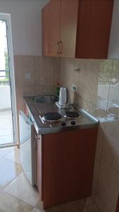 a small kitchen with a stove and a sink at Apartmani Baštrica in Budva