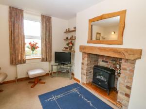 a living room with a fireplace and a mirror at Garreg Lwyd Farm in Pwllheli