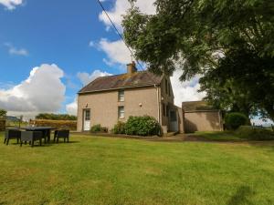 a house with a picnic table in the yard at Garreg Lwyd Farm in Pwllheli