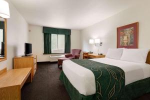 a hotel room with a large bed and a television at Travelodge by Wyndham Hermiston in Hermiston