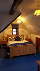 a bedroom with a large bed in a attic at Ruby Cottage in Irthlingborough