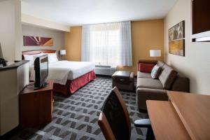 a hotel room with a bed and a couch at Sonesta Simply Suites Seattle Renton in Renton