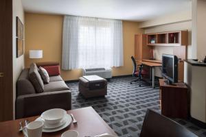 a living room with a couch and a desk in a hotel room at Sonesta Simply Suites Seattle Renton in Renton +19 photos