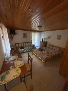 a room with four beds and tables and a wooden ceiling at Plane TREE in Mariaí