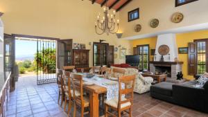 a dining room and living room with a table and chairs at Casa La Loma del Sabinal Alora by Ruralidays in Alora