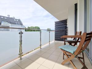 a balcony with a wooden table and a chair at Apartbaltic - Mistral 21 in Świnoujście