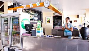 Ein Mann, der hinter dem Tresen eines Restaurants steht. in der Unterkunft C & N Resort and Spa - SHA Extra Plus in Patong Beach