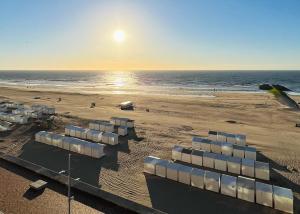 a beach with chairs on the sand and the ocean at NEPTUNE Wenduine met zeezicht - VOSPROPERTIES in Wenduine