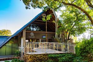 un bâtiment avec un toit bleu et un arbre dans l'établissement Seasons Golf, Leisure, Spa, à Hartbeespoort