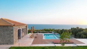 a villa with a swimming pool and the ocean at Emerald Ville in Stoupa