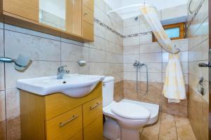 a bathroom with a sink and a toilet and a shower at Anthi Villa in Alyki