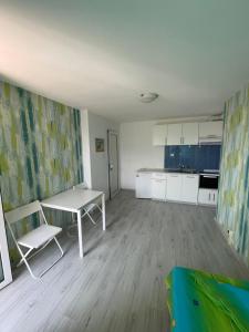 a living room with a table and a kitchen at Guest House Gabriel in Sozopol