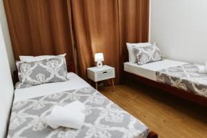 a bedroom with two beds and a lamp on a night stand at Hotel Medjugorje Irish Centre in Međugorje