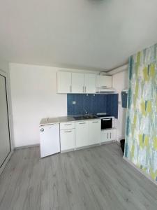 an empty kitchen with white cabinets and a sink at Guest House Gabriel in Sozopol +45 photos