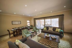 a living room with couches and a dining room at Seasons Golf, Leisure, Spa in Hartbeespoort