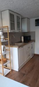 a kitchen with white cabinets and a sink and a ladder at Ružica 2 in Makarska