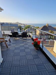 balcón con mesa, sillas y vistas al océano en The Trelinda Guest House, en Newquay