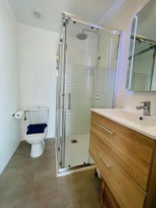 a bathroom with a shower and a toilet and a sink at Casa Iris El Cotillo in Cotillo