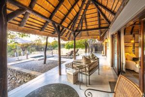 uma sala de estar exterior com um grande telhado de madeira em Villa Mushara em Namutoni