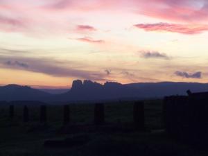 a sunset over a field with mountains in the background at Ferienpension Gabriele 15 in Kurort Gohrisch