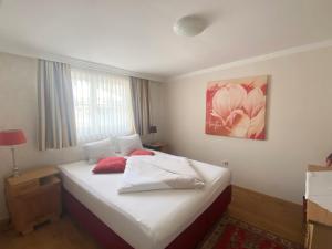 a bedroom with a bed, desk, and a painting on the wall at Seehotel Astoria in Pörtschach am Wörthersee