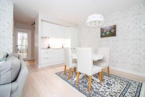a kitchen and dining room with a table and chairs at Seagulls&Dunes APTw/terrace, 2min to the Beach, by Cohost in Klaipėda