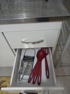 eine Schublade mit Geschirr in einem weißen Schrank in der Unterkunft Residencial Joed 2 in Dourados